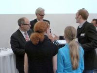 Senator Rabe überreicht Schülern des Grootmoor einen Gutschein für Brennstoffzellen zum Experimentieren.